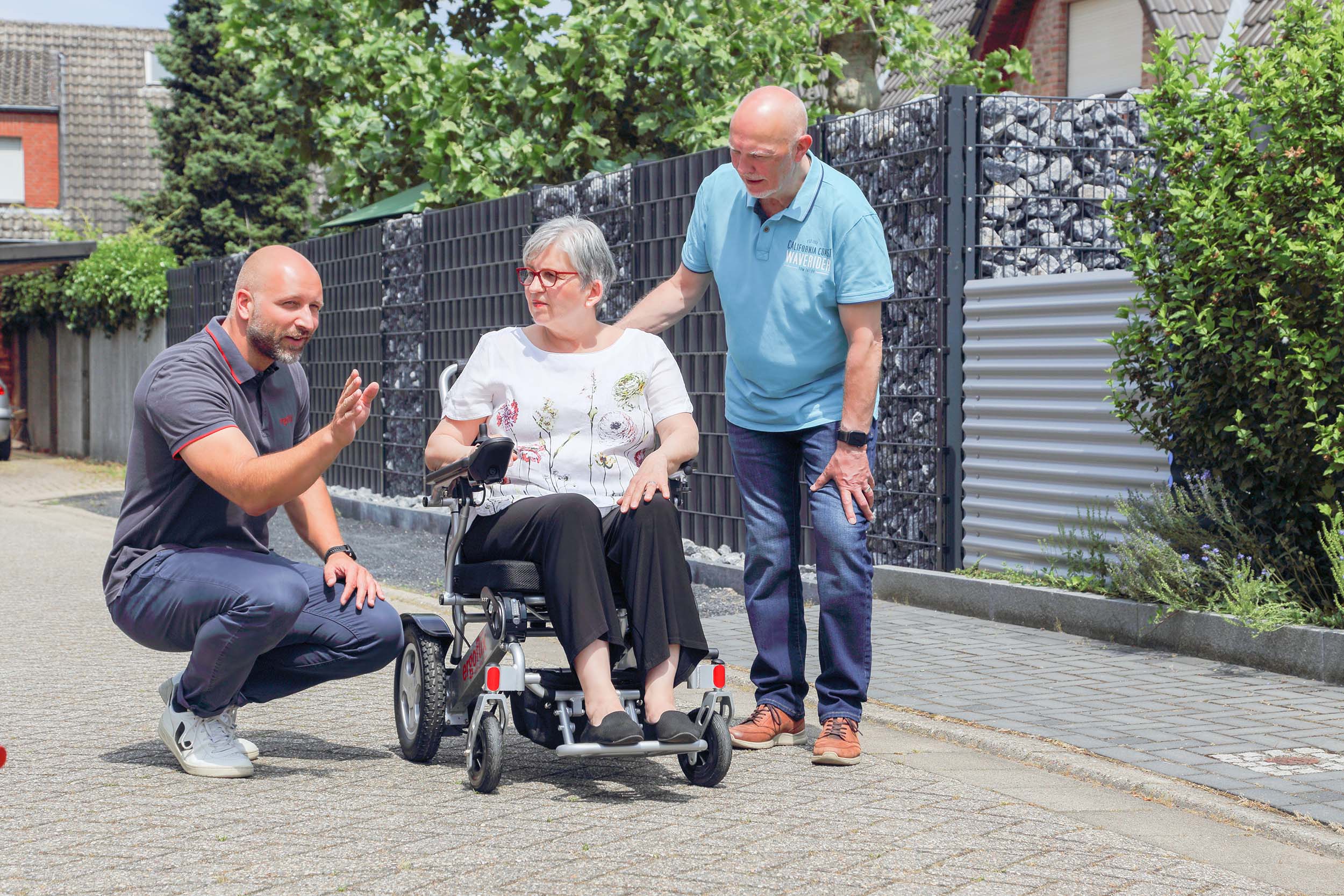 Ergoflix Mitarbeiter erklärt paar den Elektrischen Rollstuhl