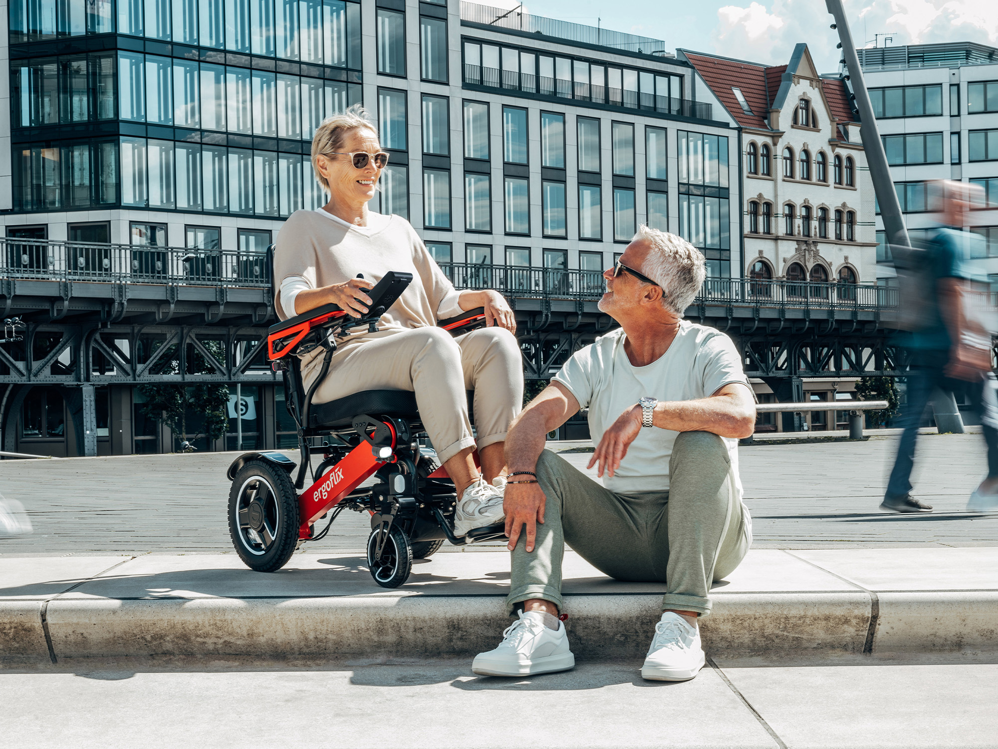 Femme en fauteuil roulant électrique ergoflix discutant avec un homme en ville
